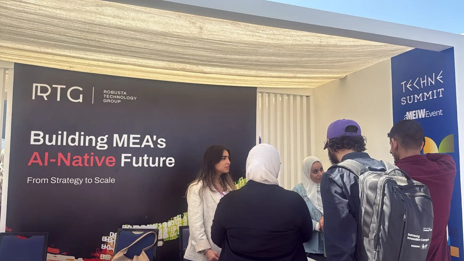 Conversations at the RTG booth beneath the Building MEA’s AI-Native Future display